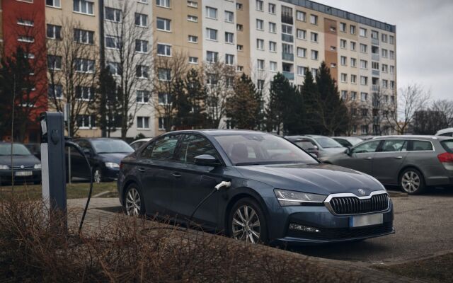 Plug-in hybrid zaparkovaný pred bytovkou v Bratislave s nabíjacím káblom