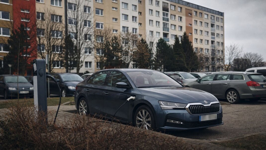 Plug-in hybrid zaparkovaný pred bytovkou v Bratislave s nabíjacím káblom