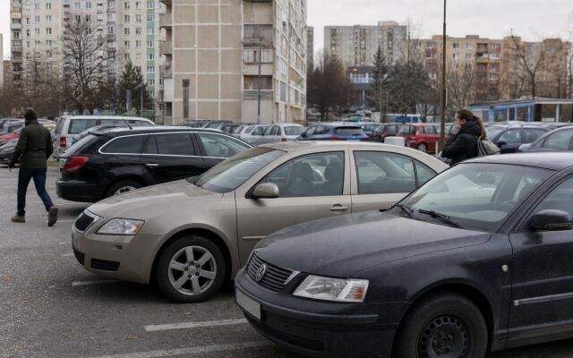 Parkovisko v Bratislave s autami a mestskou architektúrou v pozadí