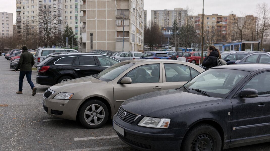 Parkovisko v Bratislave s autami a mestskou architektúrou v pozadí