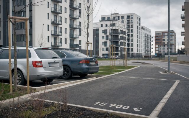 Parkovacie miesto pred novostavbou v Bratislave s cenovkou a nápisom DPH
