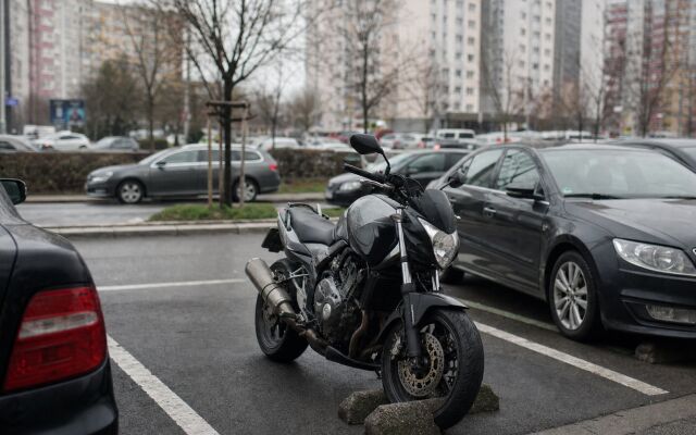 Motorka zaparkovaná na ulici v Bratislave s parkovacím automatom v pozadí
