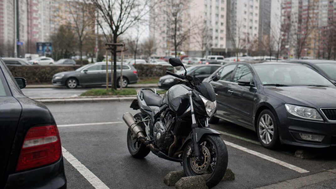 Motorka zaparkovaná na ulici v Bratislave s parkovacím automatom v pozadí