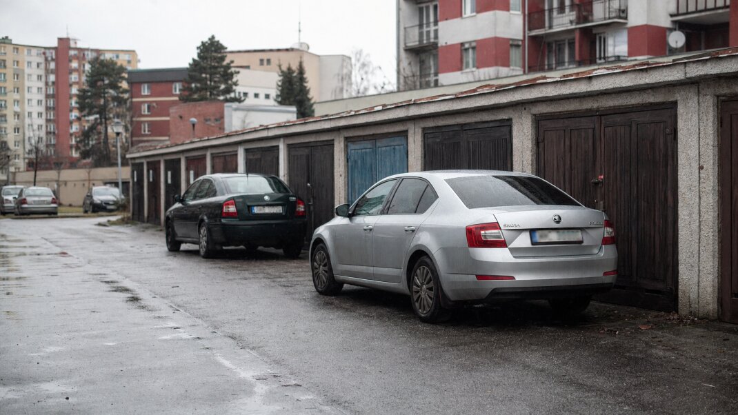 Vonkajšie parkovisko s autami v slovenskom meste, porovnanie s garážou