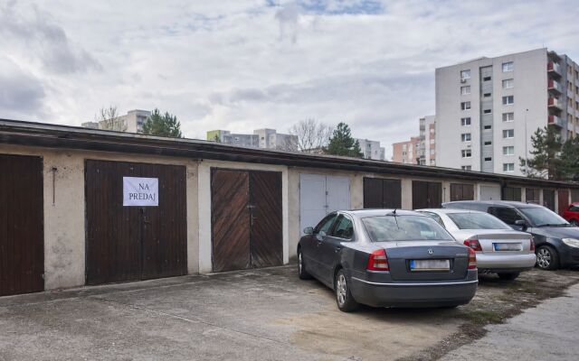 Garážové státia v Petržalke s modernými budovami v pozadí