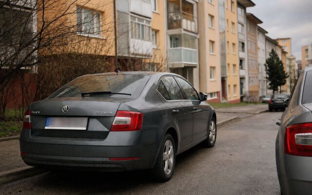 Rodina s dvoma autami pred panelákom v Bratislave, parkovacie miesta sú obmedzené.