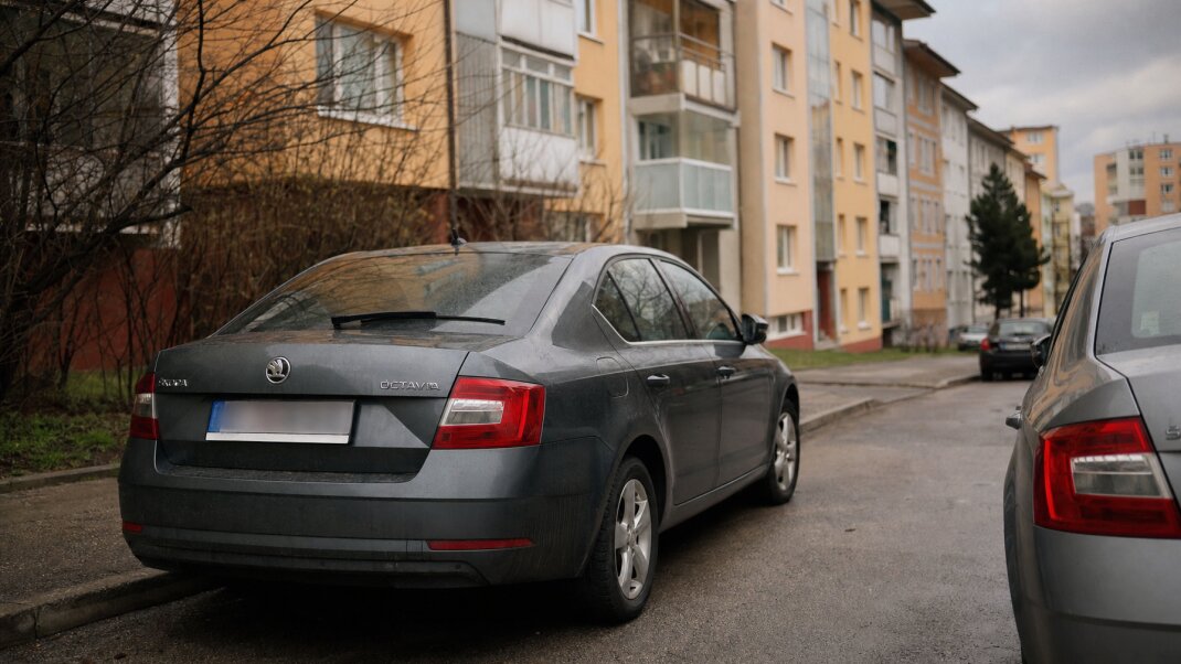 Rodina s dvoma autami pred panelákom v Bratislave, parkovacie miesta sú obmedzené.