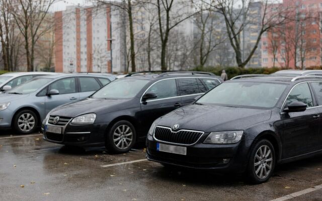 Parkovisko v centre Bratislavy s autami a mestskou architektúrou na pozadí