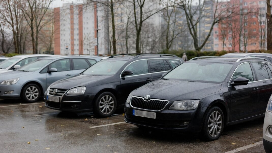 Parkovisko v centre Bratislavy s autami a mestskou architektúrou na pozadí