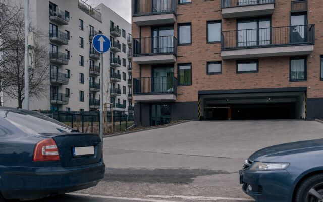 Parkovacie státia pred novostavbou v Bratislave s modernou architektúrou