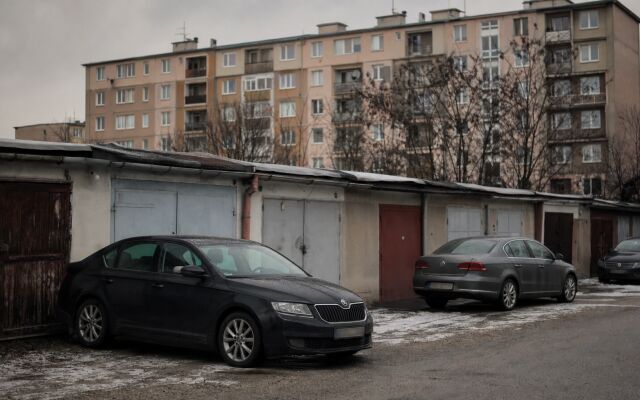 Parkovisko v Dúbravke s autami a modernými garážami v pozadí