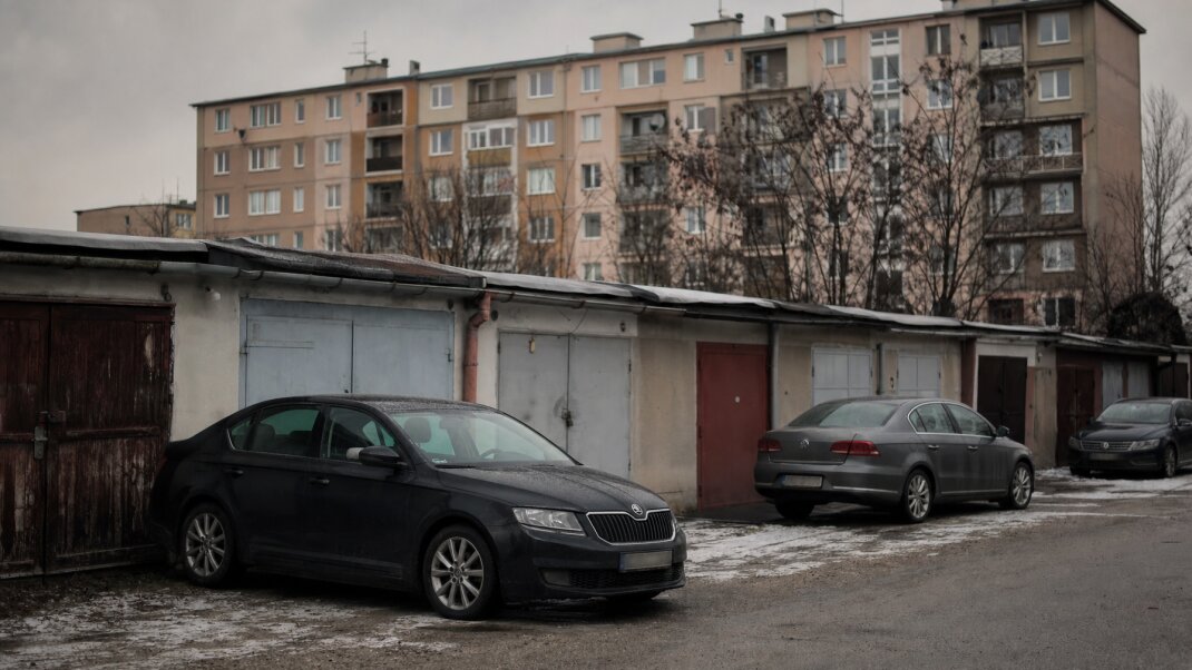 Parkovisko v Dúbravke s autami a modernými garážami v pozadí
