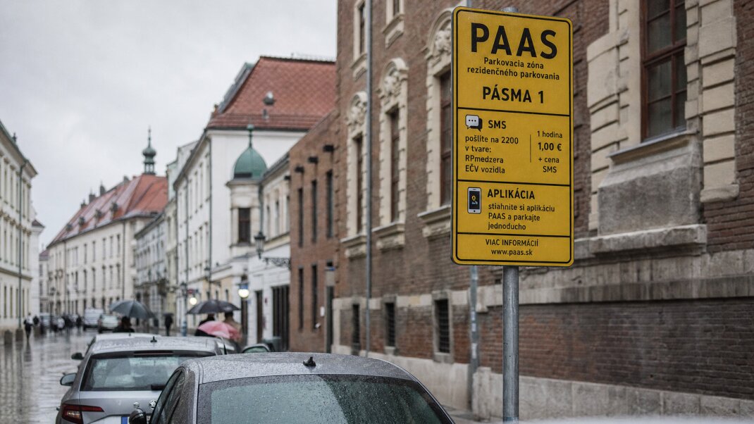 Parkovisko v centre Bratislavy s autami a obchodnými centrami v pozadí