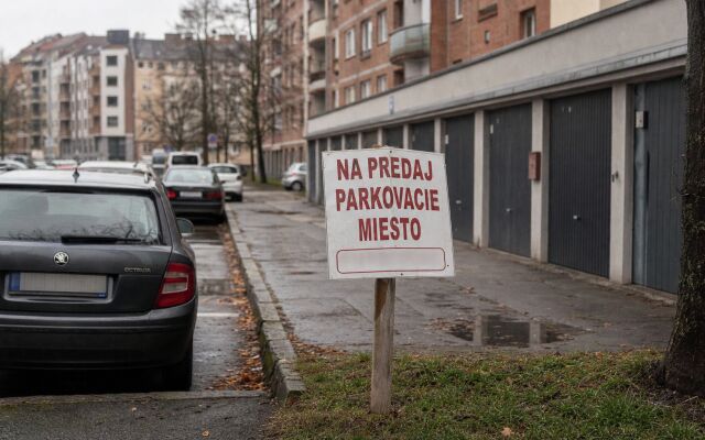 Parkovacie miesto pred novostavbou v Bratislave s autami zaparkovanými na ulici