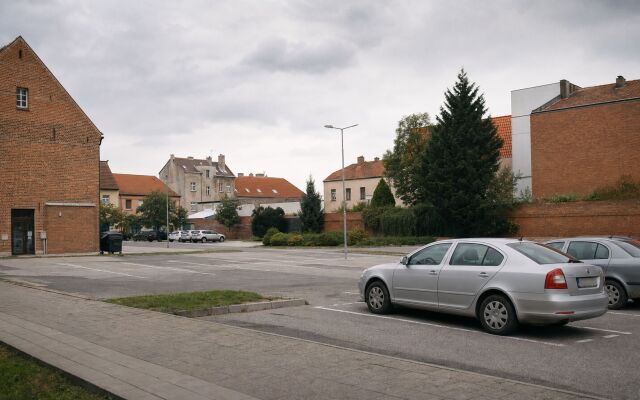 Parkovacie miesto na predaj v Senci s cenovkami a okolitými budovami