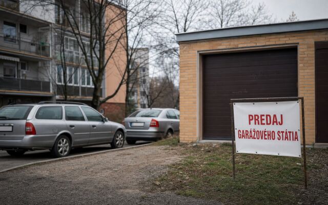 Parkovacie miesto na predaj v Trenčíne s garážou a autami v pozadí
