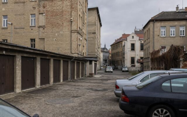 Parkovacie miesto v Bratislave s autami a okolitou architektúrou
