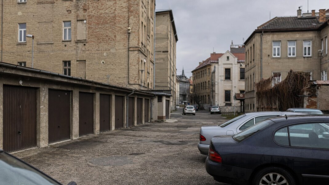 Parkovacie miesto v Bratislave s autami a okolitou architektúrou