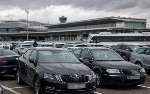 Parkovacie miesta pri letisku Budapešť s autami a terminálom v pozadí
