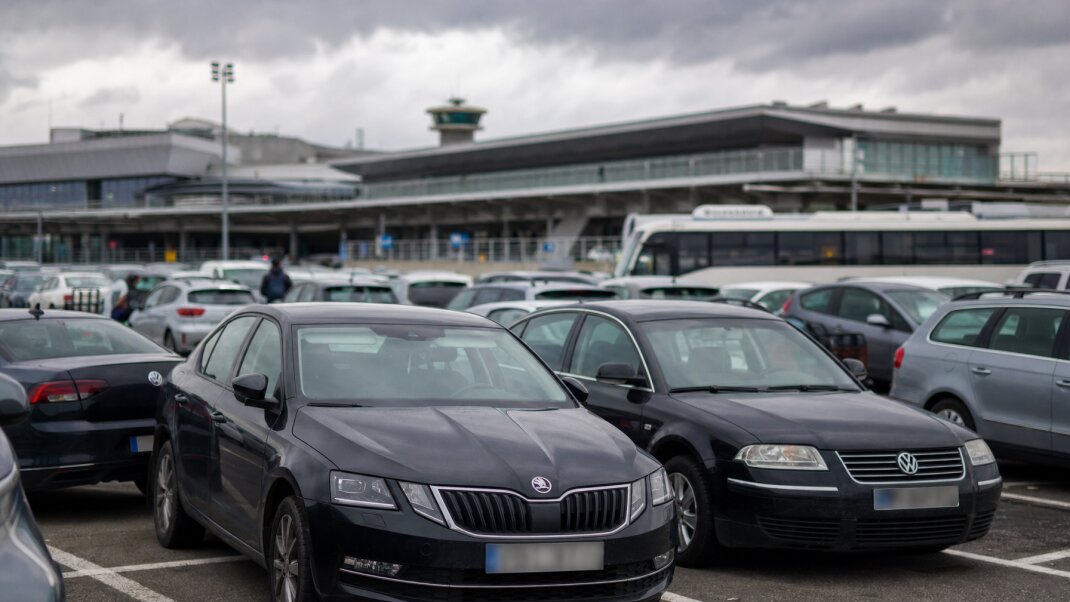 Parkovacie miesta pri letisku Budapešť s autami a terminálom v pozadí