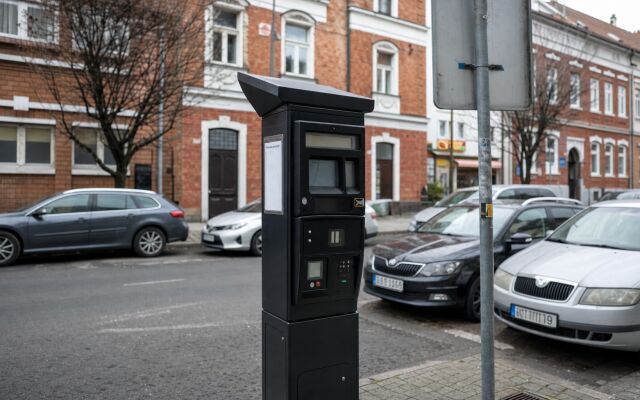 Parkovacie miesta v centre Lučenca s autami a mestskou architektúrou