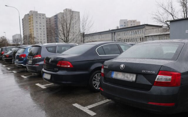 Parkovisko pred nemocnicou v Bratislave s autami a pacientmi prichádzajúcimi na vyšetrenie