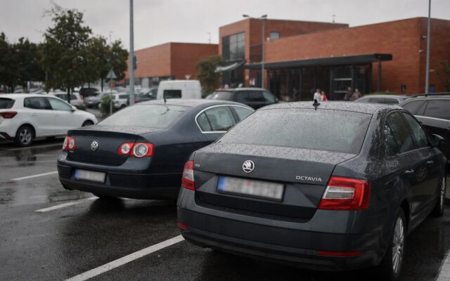 Parkovisko pred nákupným centrom v Bratislave s autami a zákazníkmi