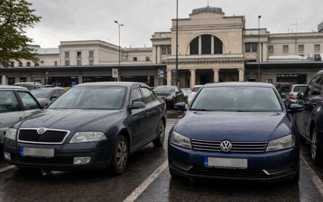 Parkovisko pred železničnou stanicou v Košiciach s autami a cestujúcimi
