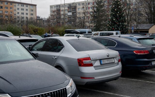 Parkovisko v Bratislave s vianočnou výzdobou a autami zaparkovanými na ulici