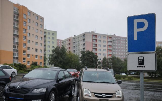 Parkovisko v Humennom s autami a informačným tabuľom o pravidlách parkovania