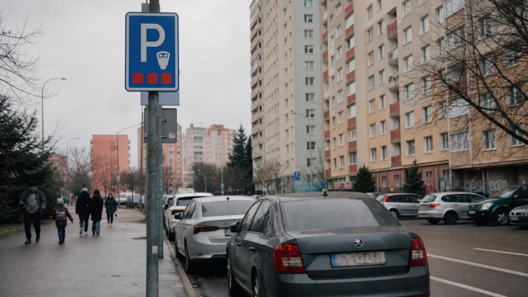 Parkovacie miesta v Ružinove s označením PAAS a autami na ulici