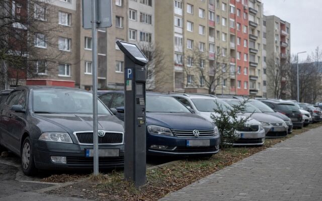 Parkovacie miesta v centre Vranova nad Topľou s autami a mestskou architektúrou
