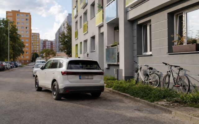 Zdieľané auto parkované pred moderným bytovým domom v Bratislave