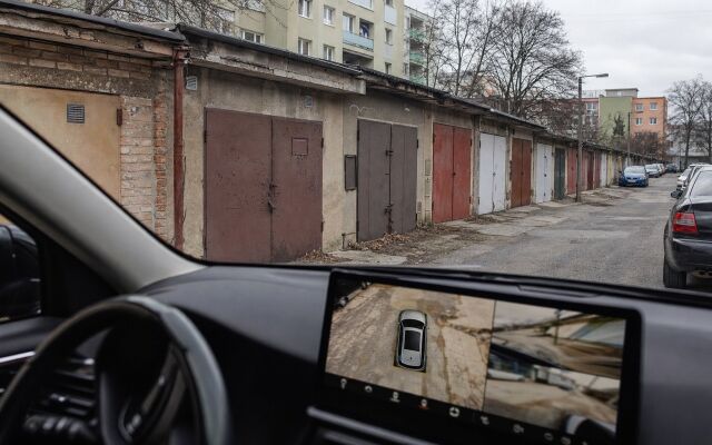 Nové auto parkované pred starou garážou s technológiou 360-stupňovej kamery