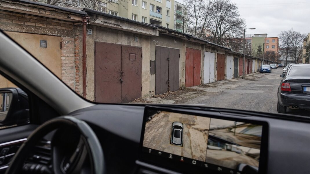 Nové auto parkované pred starou garážou s technológiou 360-stupňovej kamery