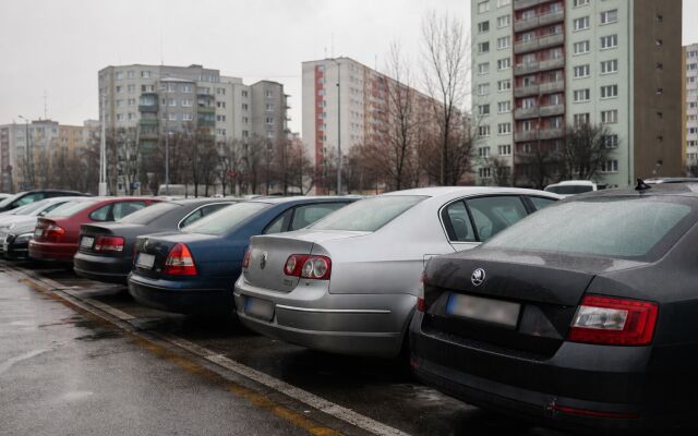 Parkovacie miesto v Petržalke s autami a panelákmi v pozadí