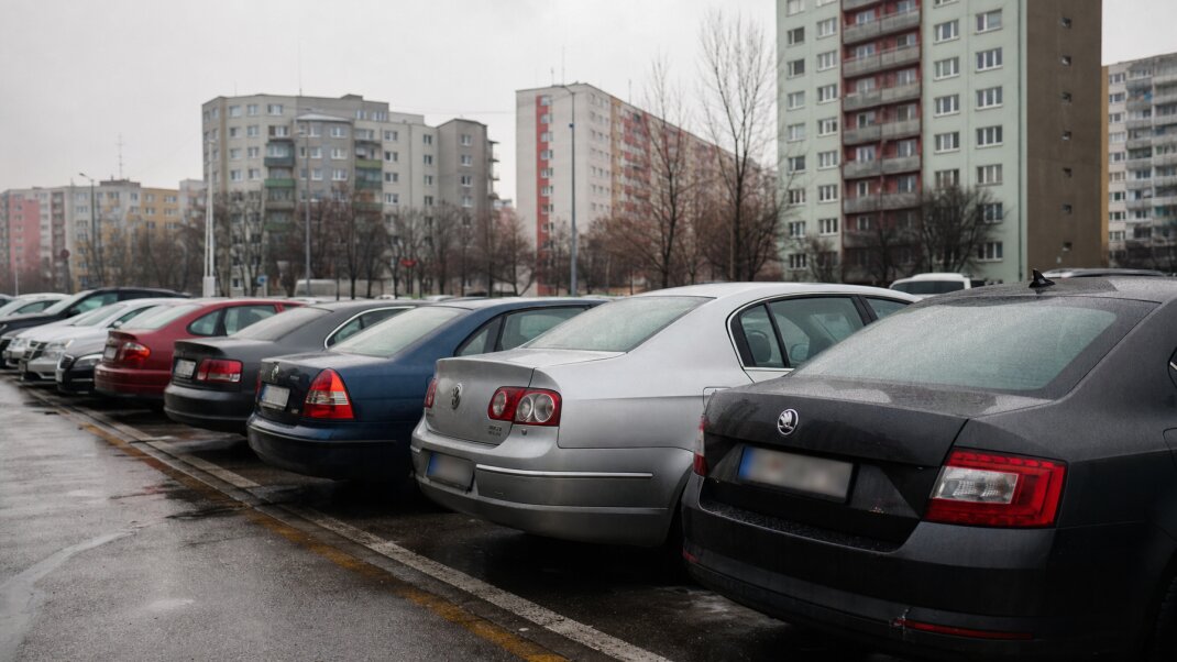 Parkovacie miesto v Petržalke s autami a panelákmi v pozadí