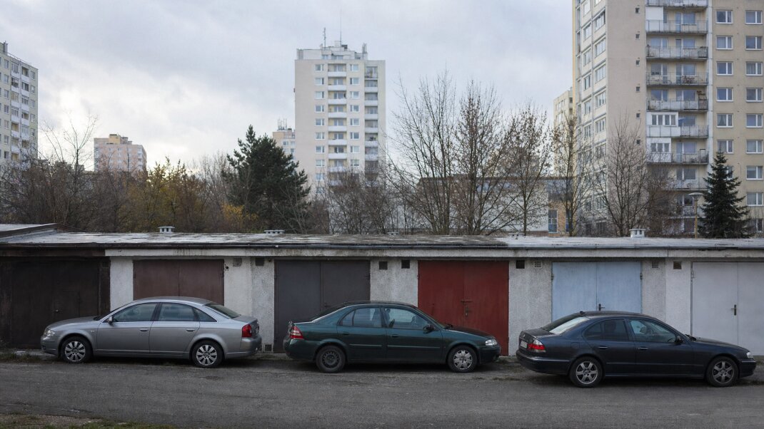 Preplnené parkovisko v Petržalke s autami zaparkovanými medzi panelákmi
