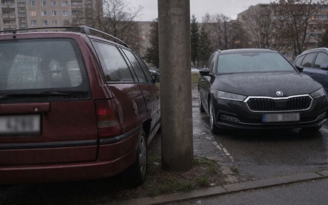 Preplnené parkovisko na sídlisku s autami zaparkovanými tesne pri sebe