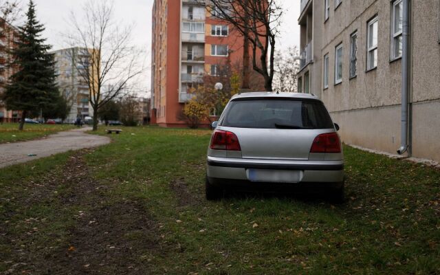 Auto zaparkované na tráve medzi panelákmi v Bratislave