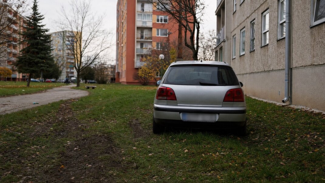 Auto zaparkované na tráve medzi panelákmi v Bratislave